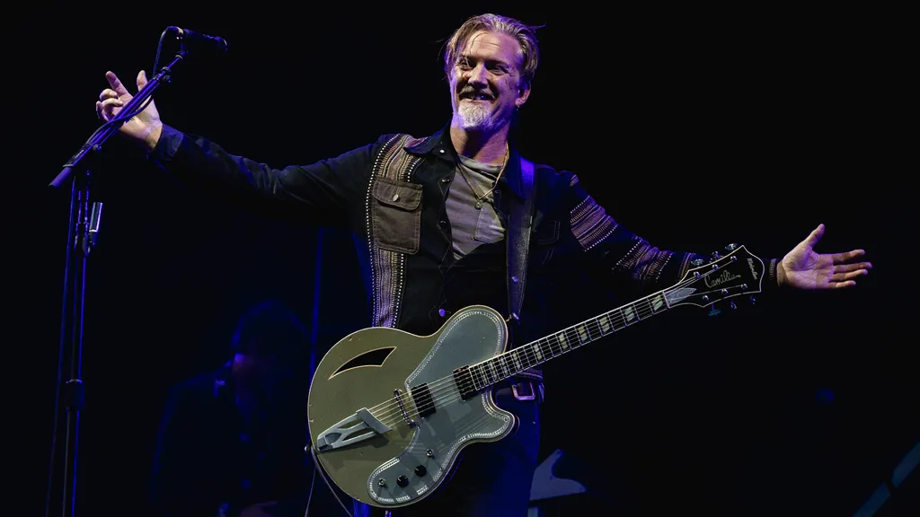 A photo of Queens Of The Stone Age singer/guitarist Josh Homme, headlining a stage at Glastonbury in 2023