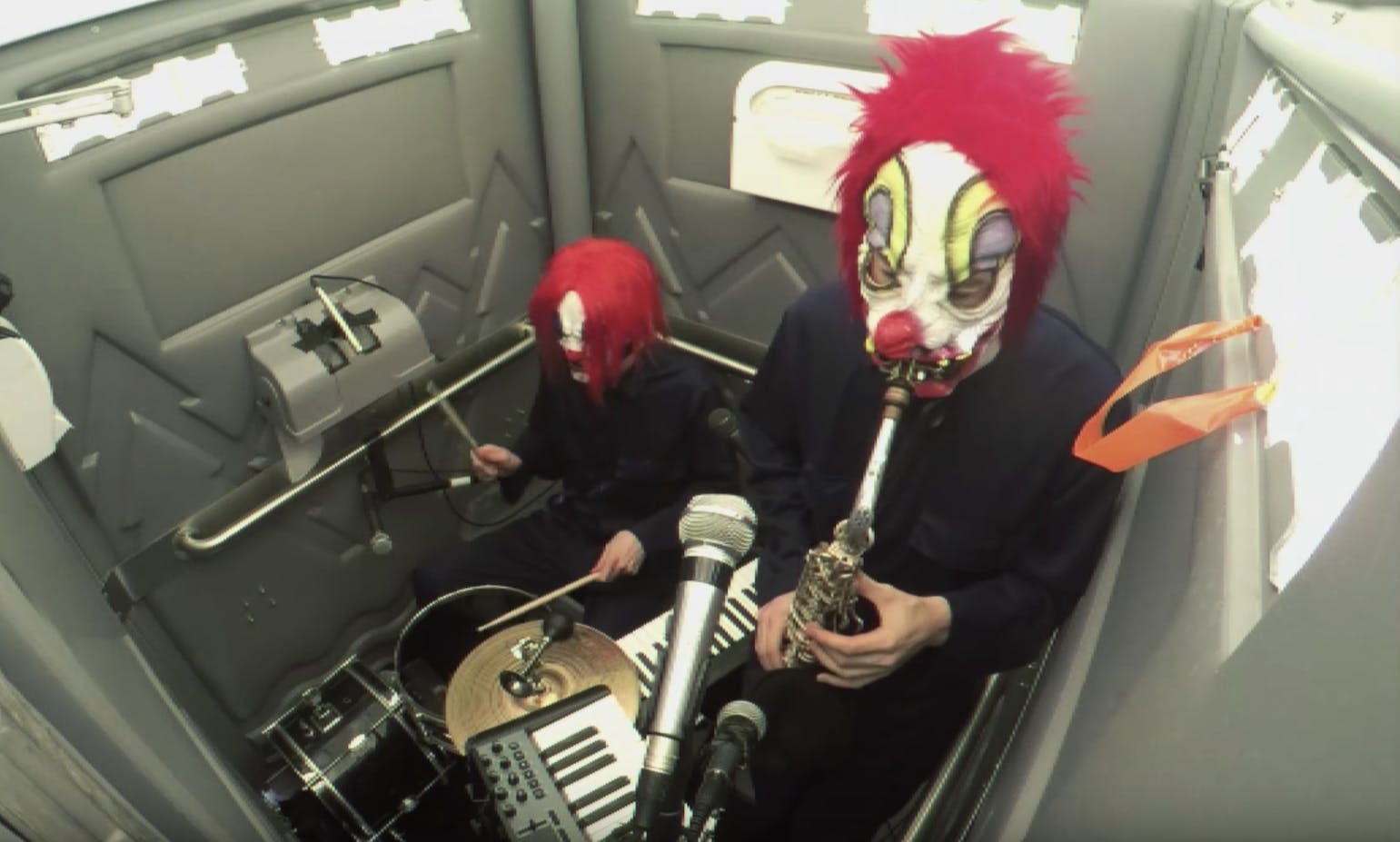 Two Clowns Playing Grindcore, Drum And Bass And Jazz In A Porta-Potty