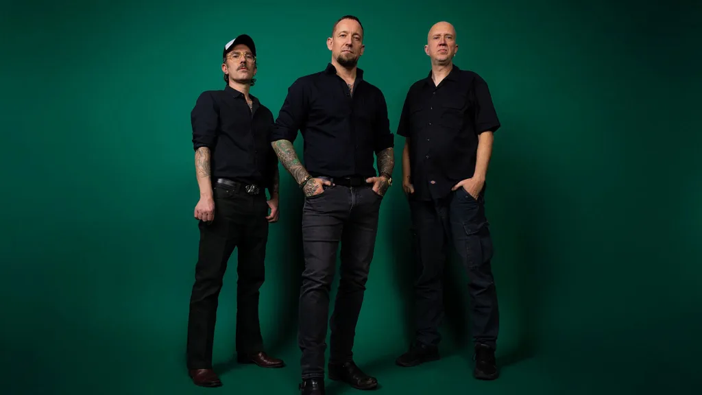 A photo of hard rock band Volbeat – Michael Poulsen (vocals, guitar), Jon Larsen (drums) and Kaspar Boye Larsen (bass)