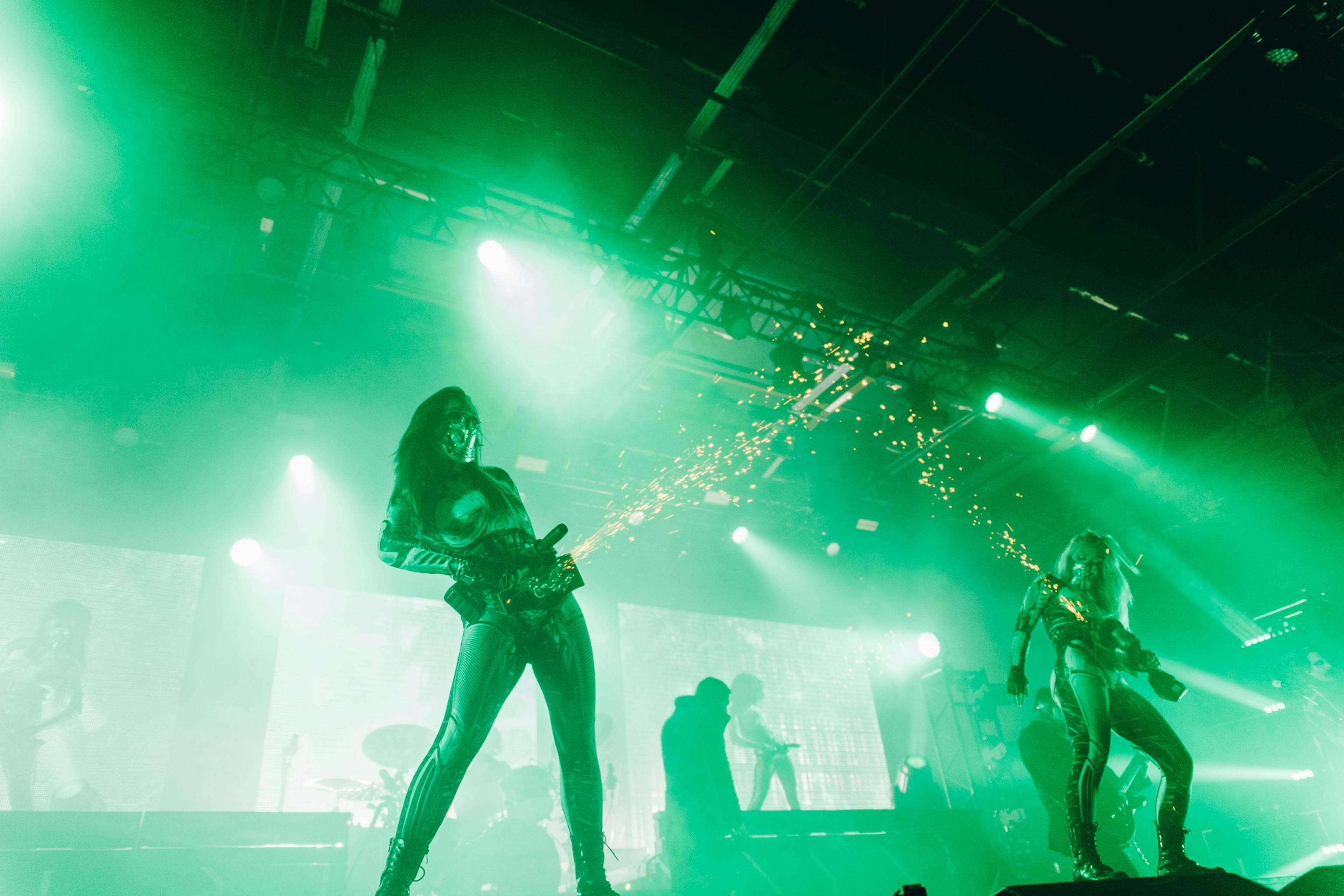 A shot of two dancers with angle grinders with the gothic metal band Motionless In White onstage in Manchester